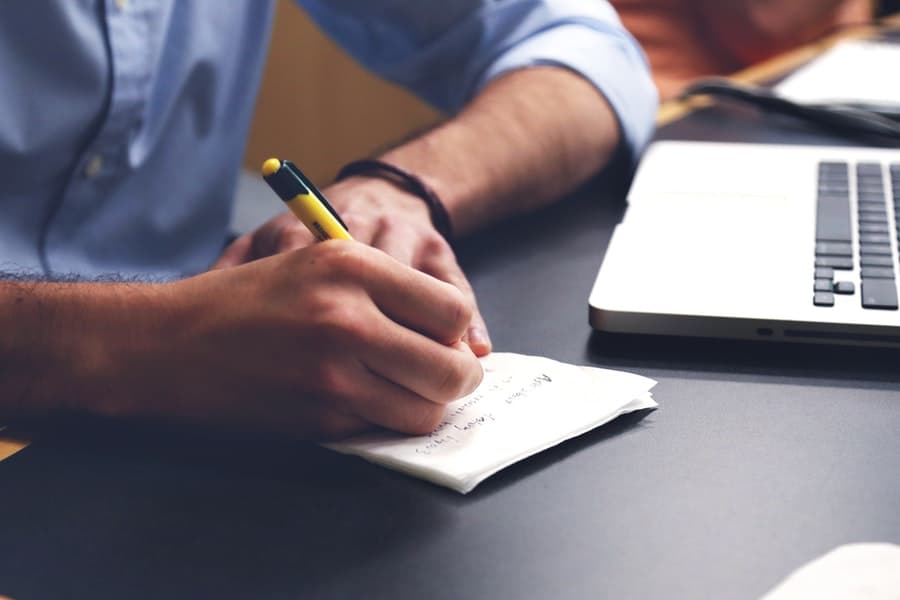 man writing on a pad