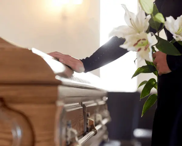 woman standing next to casket